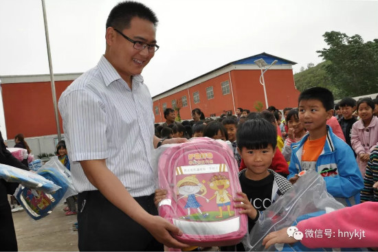 亚坤集团副总裁曹俊岭为学生发放书包.jpg